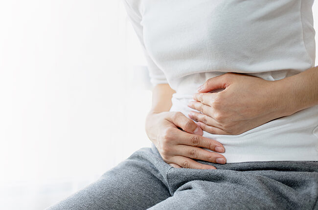 月経困難症でお腹をおさえる女性